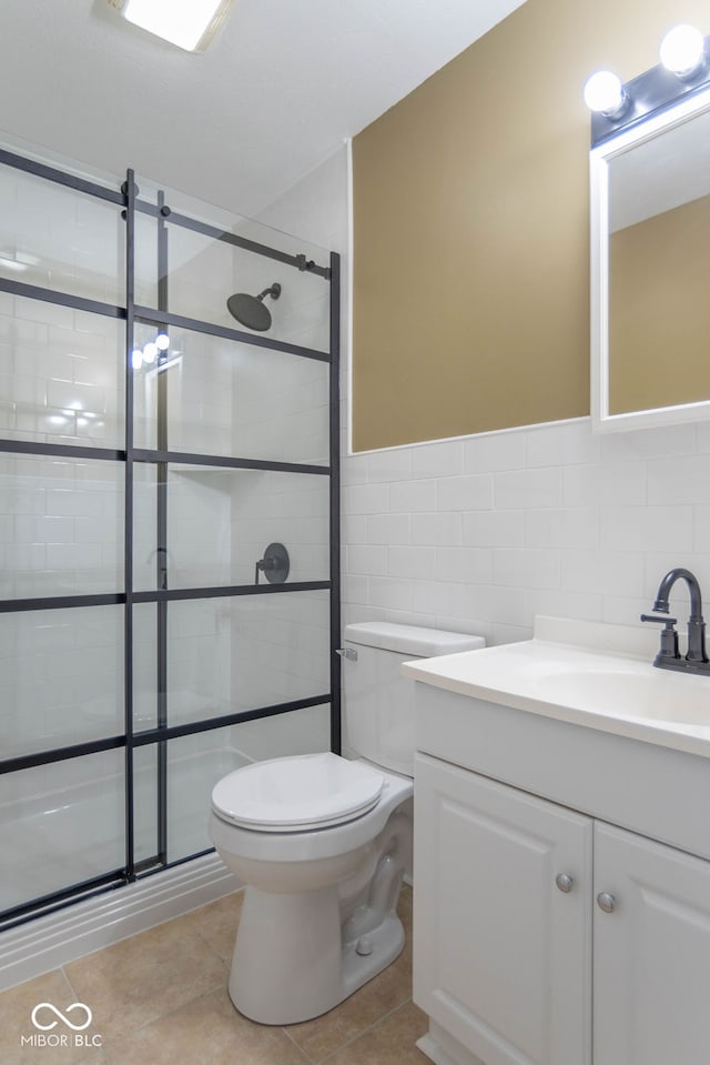 bathroom with tile patterned flooring, vanity, walk in shower, and tile walls