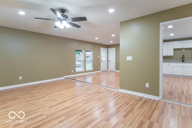 interior space with light wood-type flooring, ceiling fan, and sink