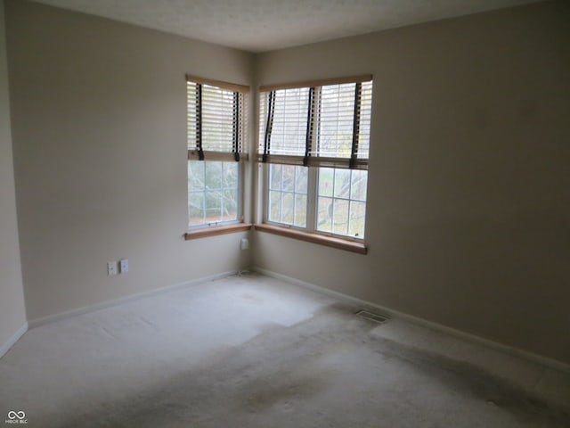 carpeted empty room featuring a textured ceiling