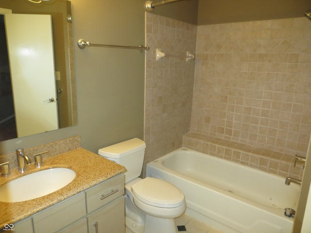 full bathroom featuring tile patterned floors, tiled shower / bath, vanity, and toilet