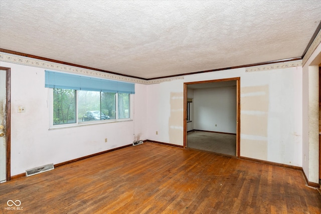 empty room with a textured ceiling, crown molding, and dark hardwood / wood-style floors