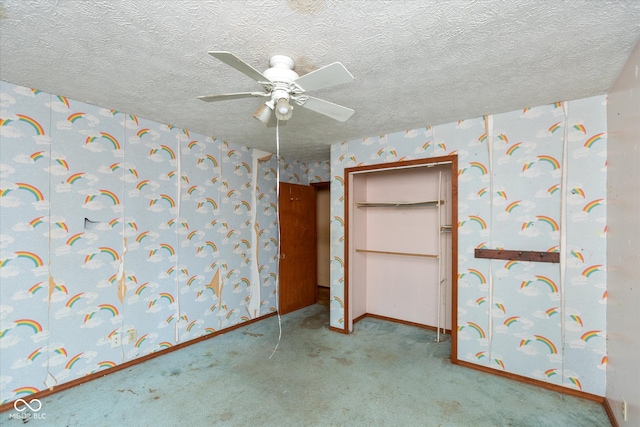 carpeted empty room with ceiling fan and a textured ceiling