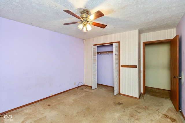 unfurnished bedroom featuring ceiling fan, a closet, light colored carpet, and a textured ceiling