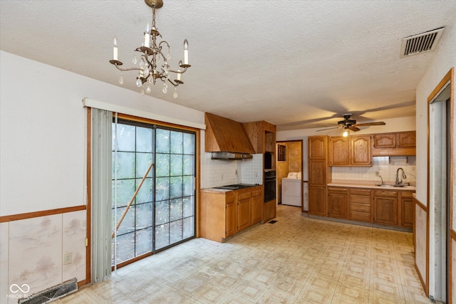 kitchen featuring sink, hanging light fixtures, tasteful backsplash, washer / clothes dryer, and black oven