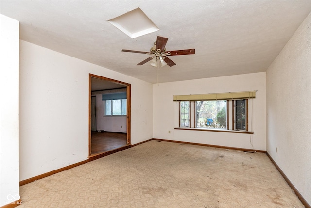 spare room featuring a textured ceiling, light colored carpet, and ceiling fan