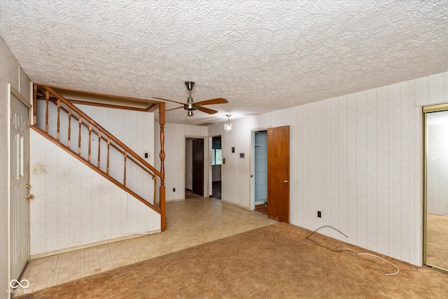 interior space with ceiling fan and a textured ceiling