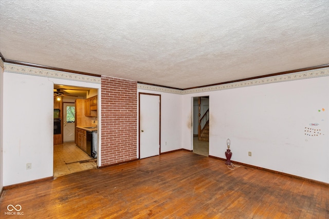 unfurnished bedroom featuring dark wood-type flooring, ensuite bathroom, sink, ornamental molding, and a textured ceiling