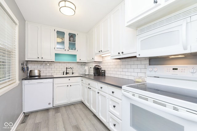 kitchen featuring sink, light hardwood / wood-style floors, white appliances, decorative backsplash, and white cabinets