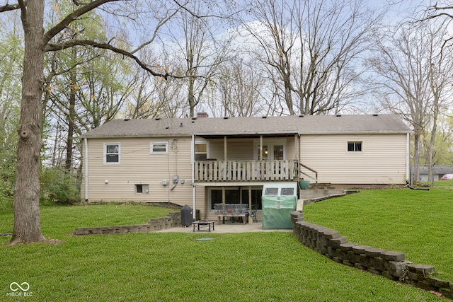 back of house featuring a lawn, a patio, and a wooden deck