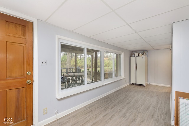 interior space featuring light wood-type flooring and a drop ceiling