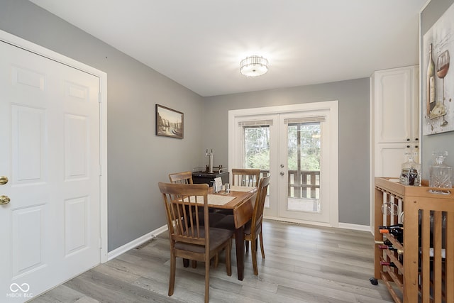 dining space featuring french doors and light hardwood / wood-style flooring