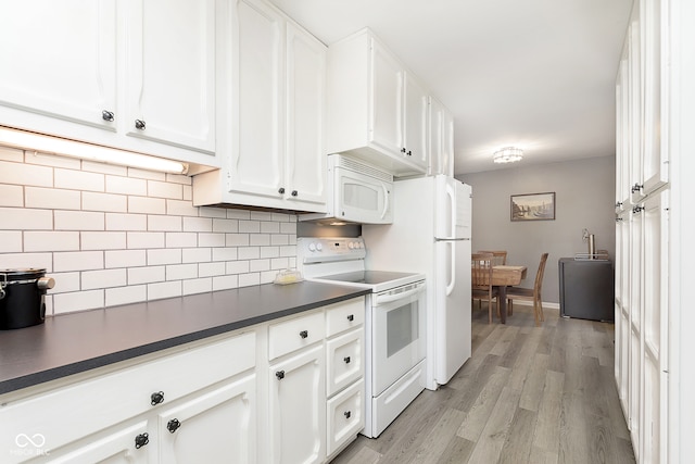 kitchen with white cabinets, light wood-type flooring, white appliances, and decorative backsplash