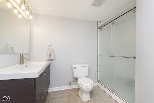 bathroom featuring baseboard heating, toilet, wood-type flooring, and walk in shower