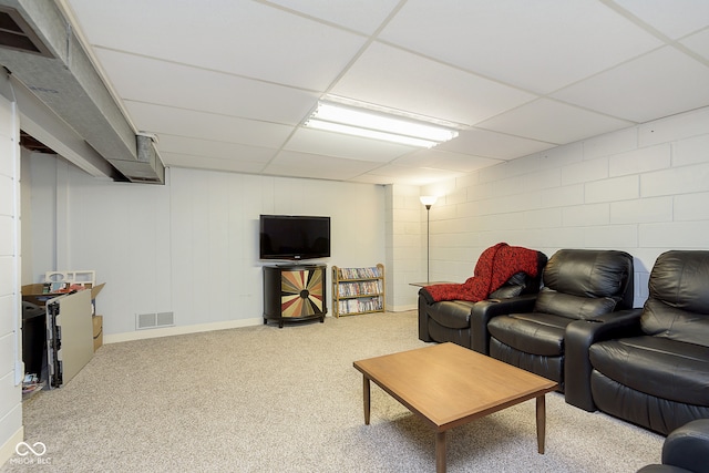 carpeted living room featuring a drop ceiling