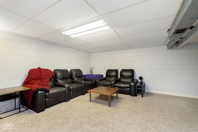 carpeted home theater featuring a paneled ceiling