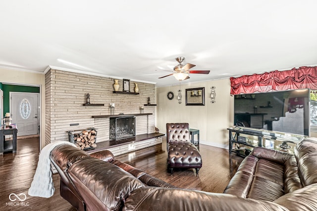 living room featuring a fireplace, wood-type flooring, ceiling fan, and crown molding