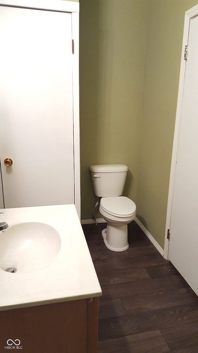 bathroom with hardwood / wood-style floors, vanity, and toilet