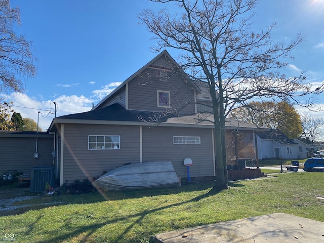 rear view of property with a lawn and central AC unit