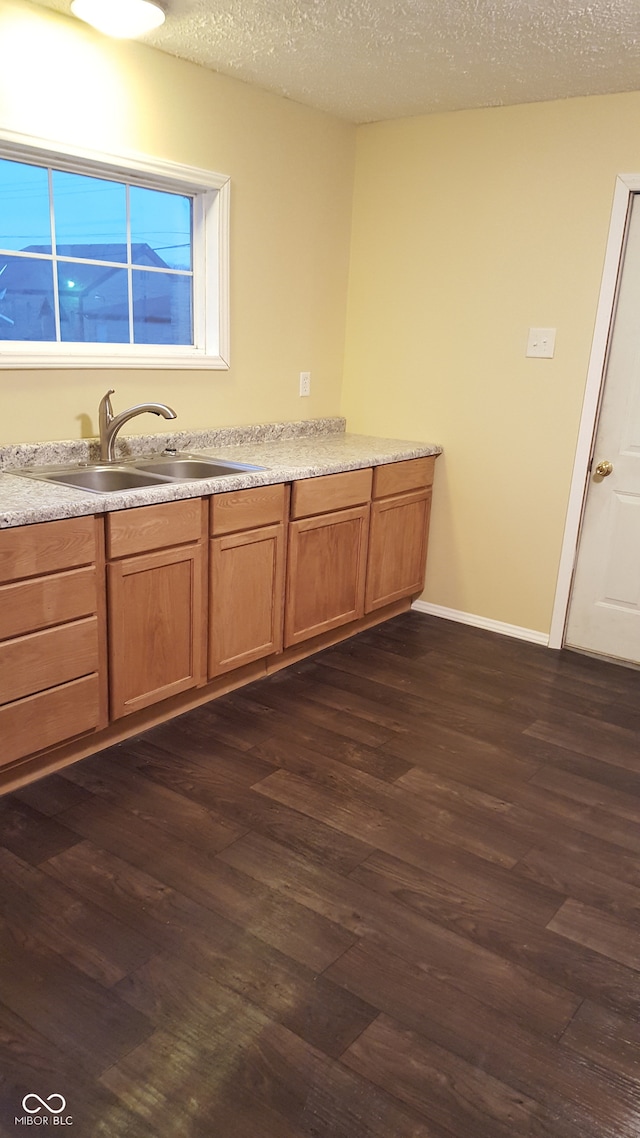 bathroom featuring hardwood / wood-style flooring, sink, and a textured ceiling