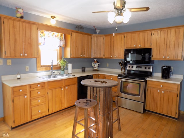 kitchen featuring sink, light hardwood / wood-style flooring, ceiling fan, and black appliances