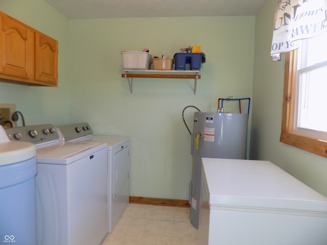 laundry area with electric water heater, cabinets, separate washer and dryer, and a textured ceiling