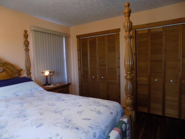 bedroom with a textured ceiling and dark hardwood / wood-style floors