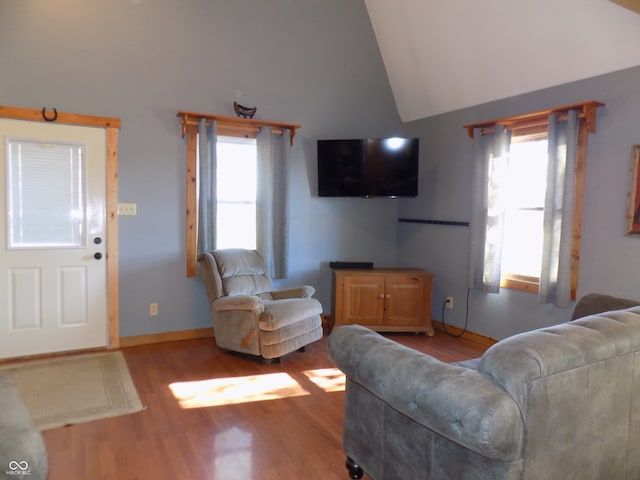 living room featuring lofted ceiling and light hardwood / wood-style flooring