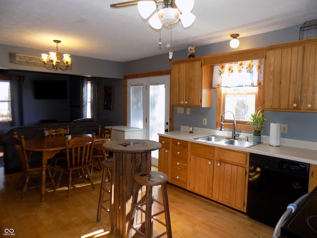 kitchen featuring ceiling fan with notable chandelier, sink, black dishwasher, decorative light fixtures, and light hardwood / wood-style floors