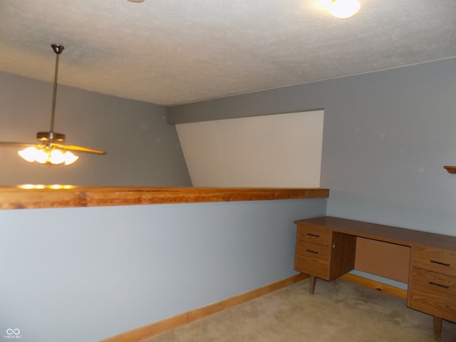 unfurnished office with a textured ceiling, light colored carpet, and ceiling fan