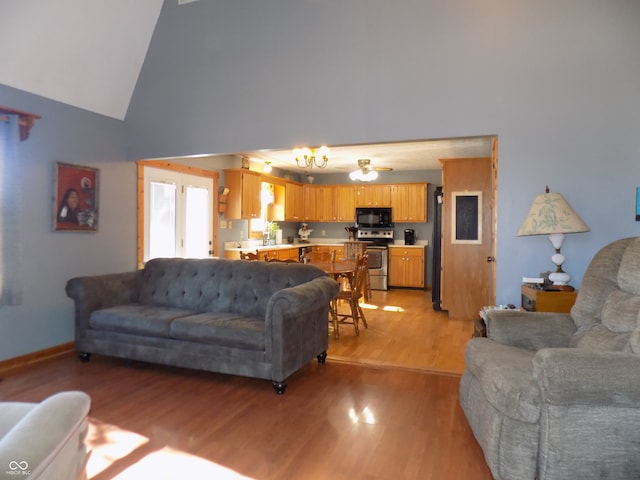 living room featuring light hardwood / wood-style floors, high vaulted ceiling, and ceiling fan