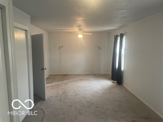 carpeted empty room featuring ceiling fan