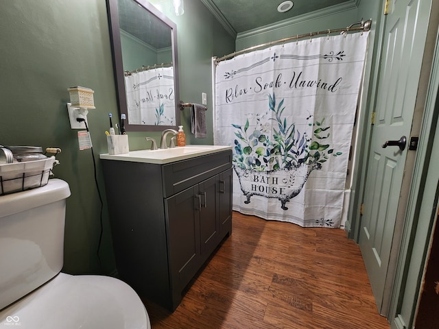 bathroom featuring walk in shower, ornamental molding, hardwood / wood-style floors, vanity, and toilet