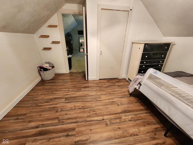 bedroom featuring hardwood / wood-style flooring, vaulted ceiling, and a closet