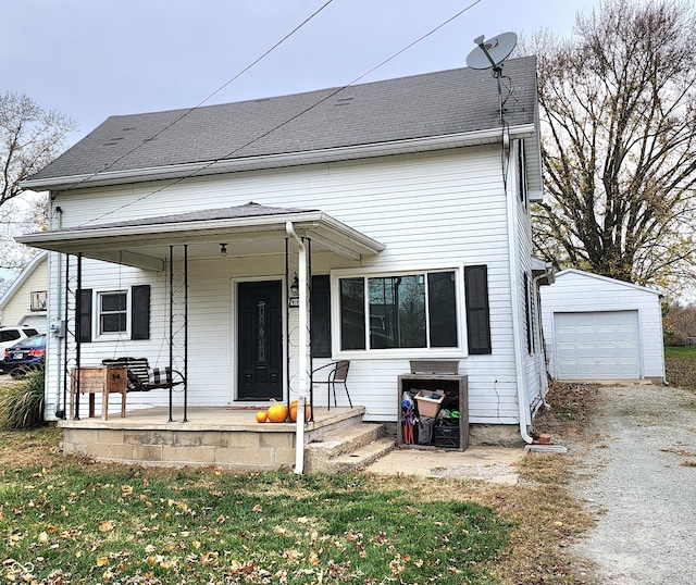 view of front facade with covered porch, a garage, and an outbuilding