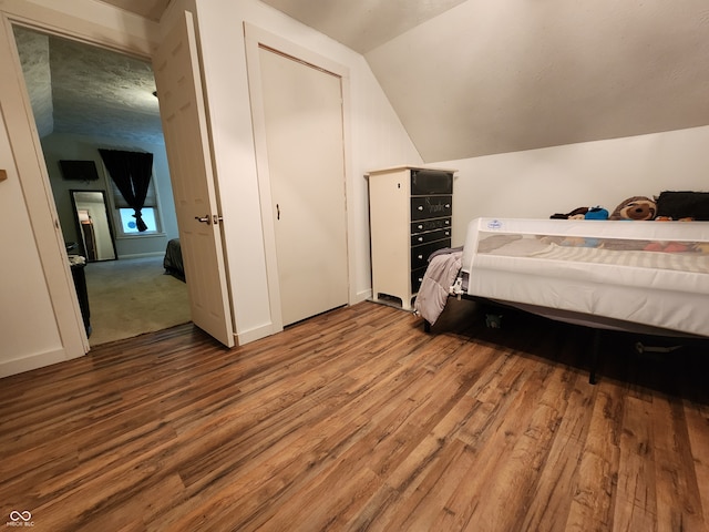 bedroom with hardwood / wood-style flooring and vaulted ceiling