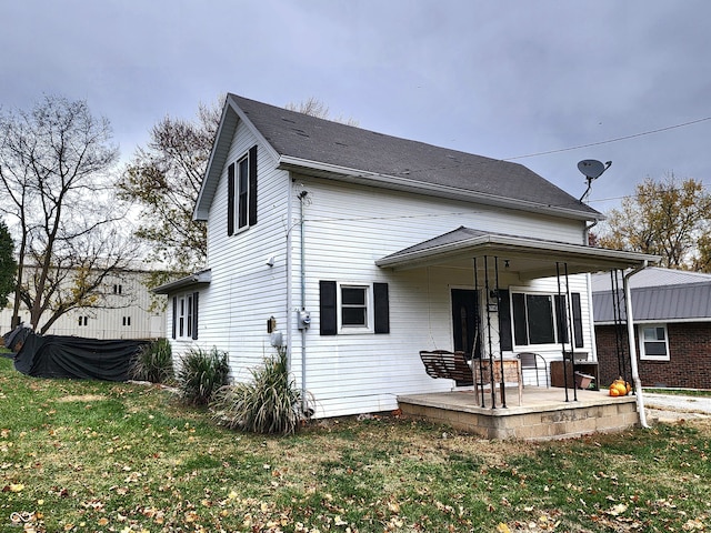 rear view of property featuring a yard