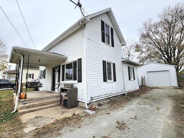 exterior space with an outdoor structure, a garage, and a porch