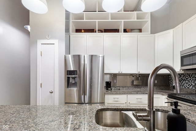 kitchen with white cabinets, dark stone countertops, and stainless steel appliances