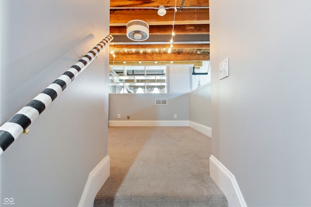 stairs featuring beam ceiling and carpet floors