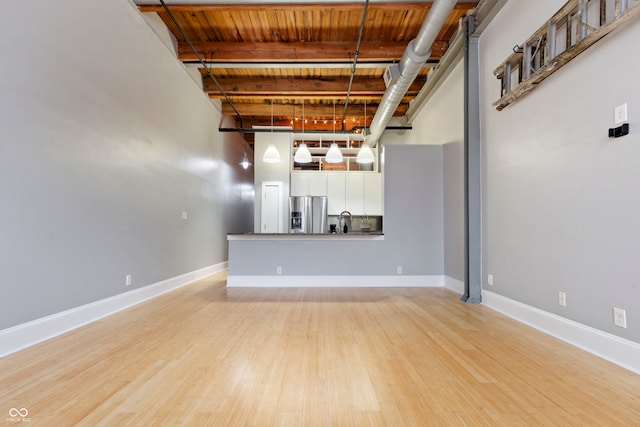 unfurnished living room with light wood-type flooring and sink