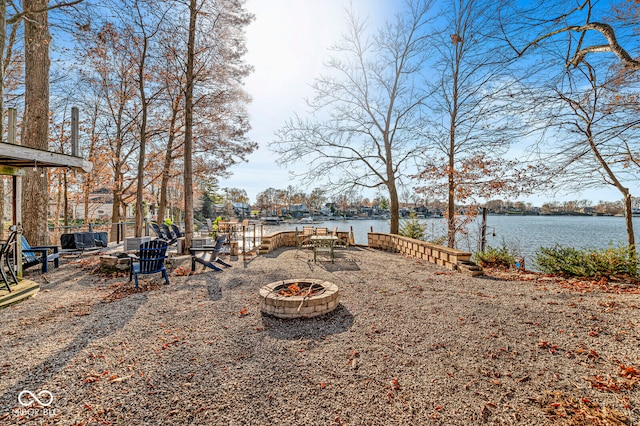 view of yard with a fire pit and a water view