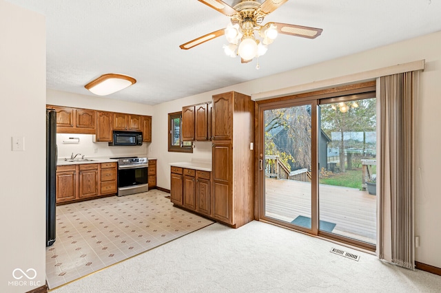 kitchen featuring sink, light colored carpet, ceiling fan, and black appliances