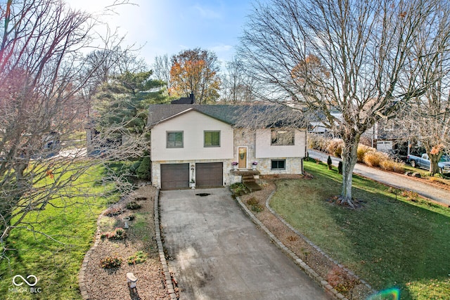 raised ranch with a front lawn and a garage