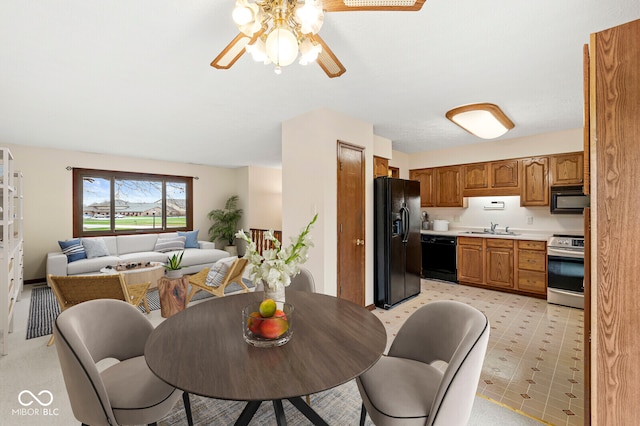 carpeted dining area featuring ceiling fan and sink