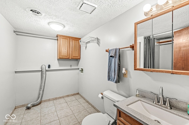 bathroom featuring tile patterned floors, vanity, a textured ceiling, and toilet