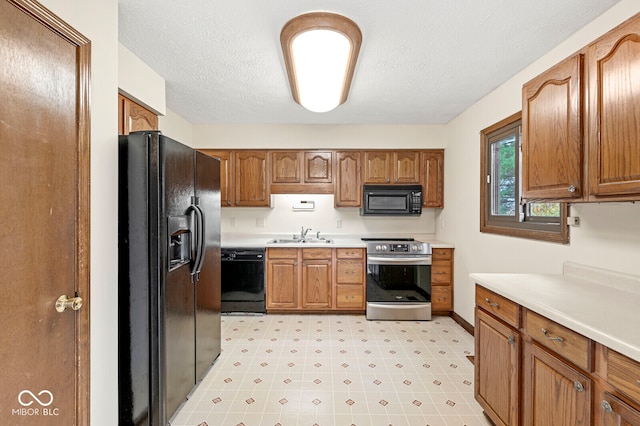 kitchen featuring sink, black appliances, and a textured ceiling