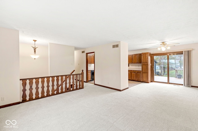 empty room with ceiling fan and light carpet