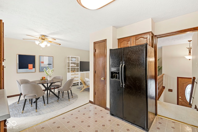 kitchen featuring black refrigerator with ice dispenser, ceiling fan, light carpet, and a textured ceiling