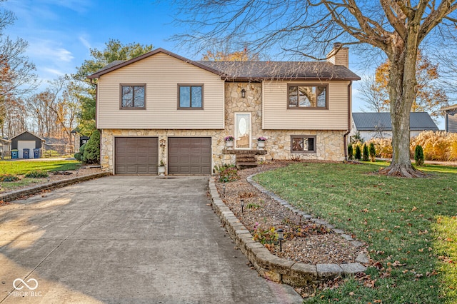 raised ranch featuring a garage and a front yard