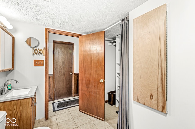 bathroom featuring vanity, a textured ceiling, toilet, and tile patterned flooring